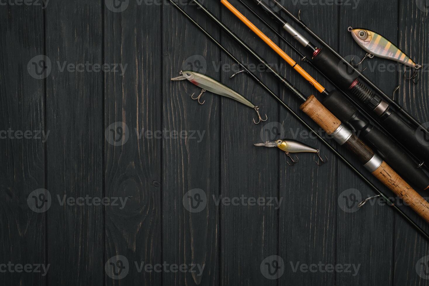 Fishing tackle - fishing spinning, hooks and lures on darken wooden background. Top view photo