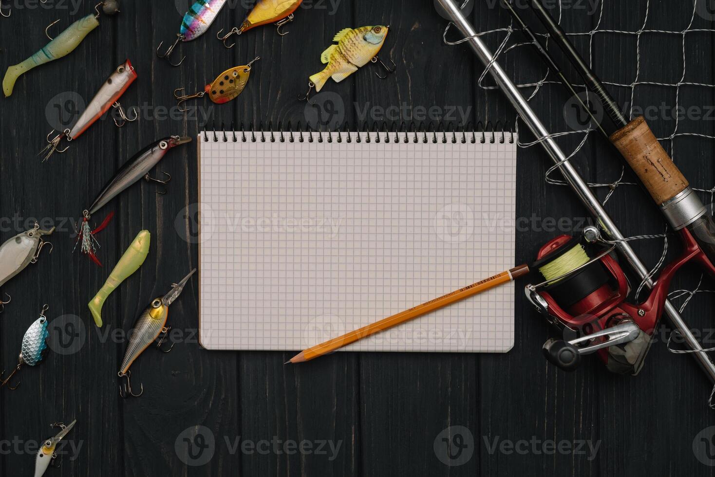 Fishing tackle - fishing spinning, hooks and lures on darken wooden background. Top view photo