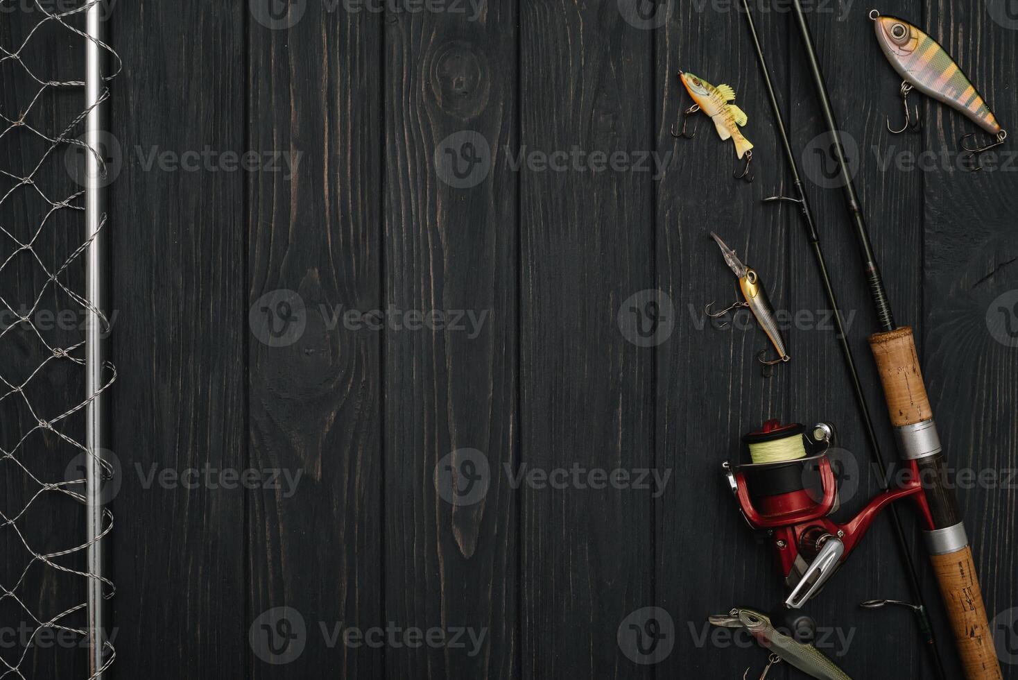 Fishing tackle - fishing spinning, hooks and lures on darken wooden background. Top view photo