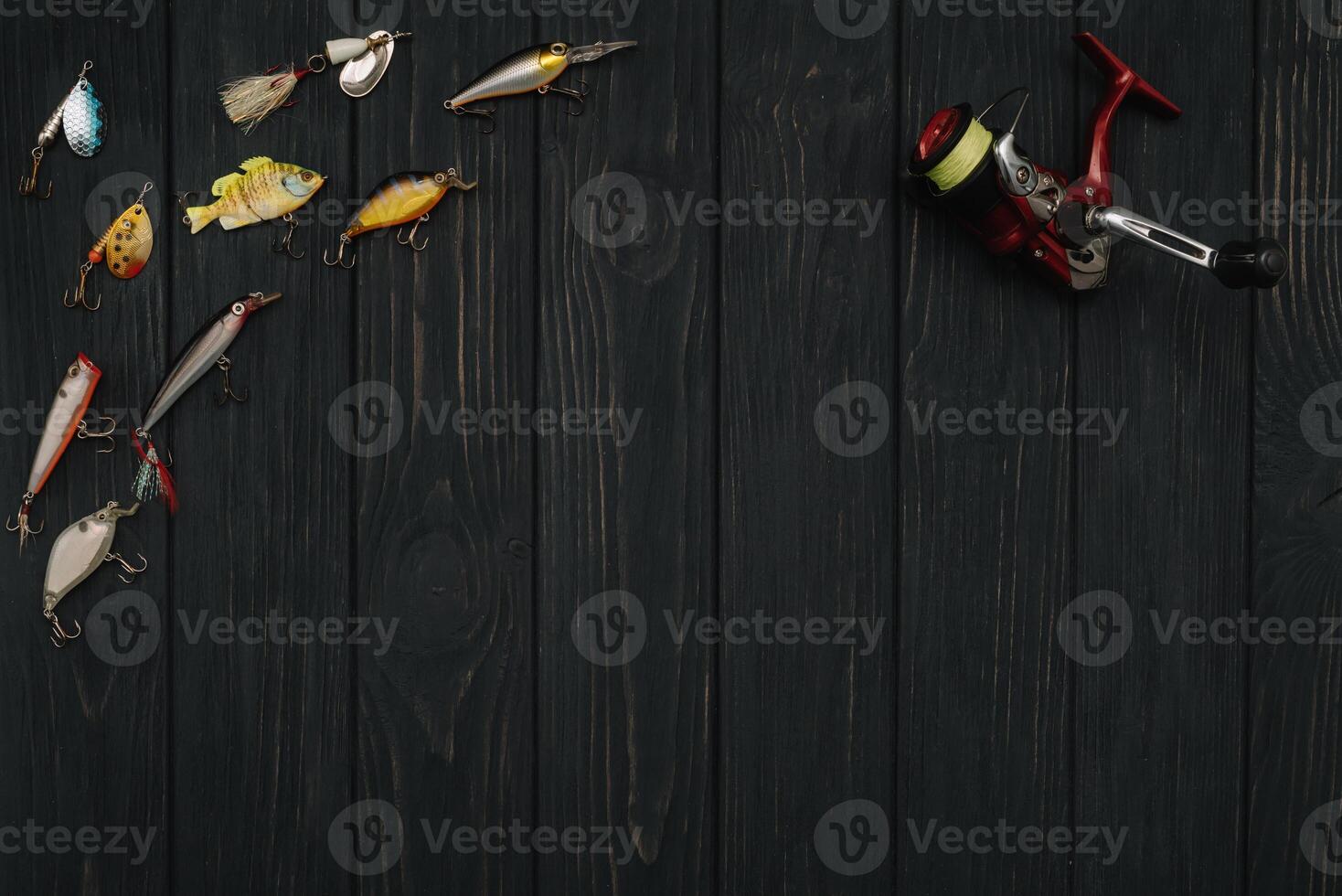 Fishing tackle - fishing spinning, hooks and lures on darken wooden background. Top view photo