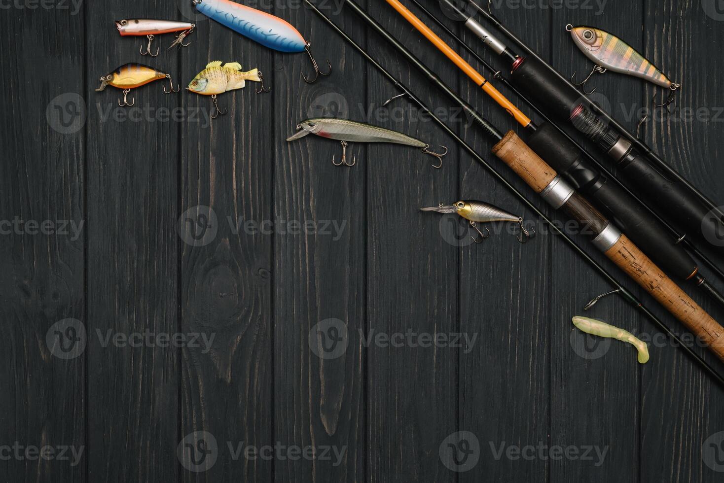 Fishing tackle - fishing spinning, hooks and lures on darken wooden background. Top view photo