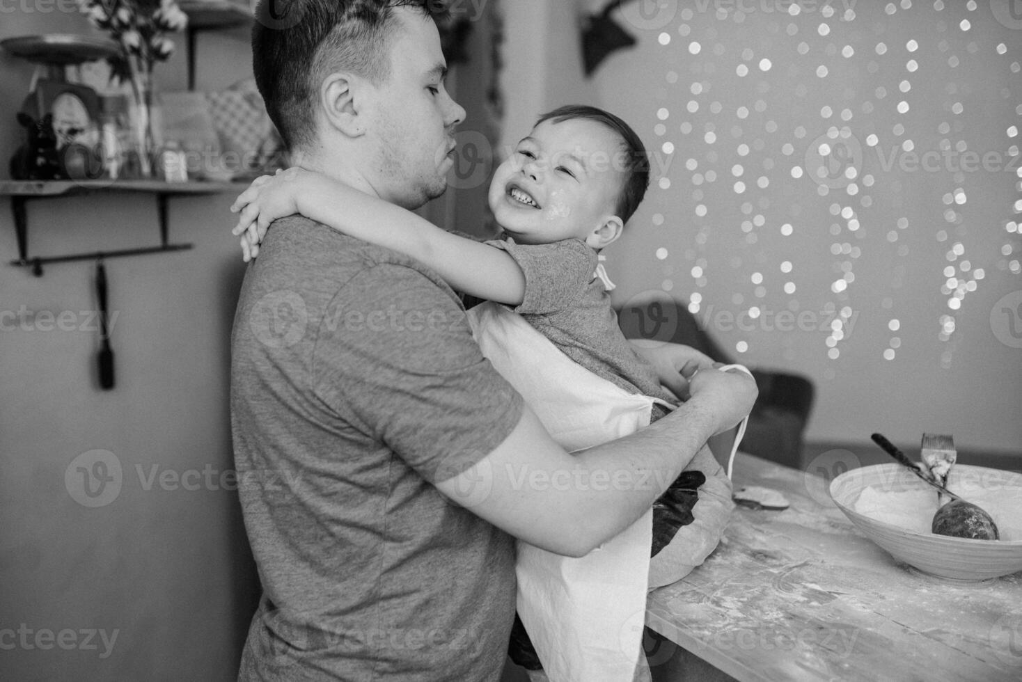 joven hombre y su hijo con horno sábana en cocina. padre con pequeño hijo en el cocina. foto