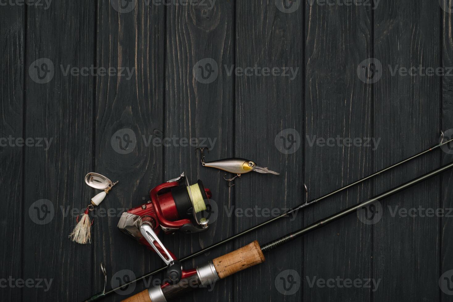 Fishing tackle - fishing spinning, hooks and lures on darken wooden background. Top view photo