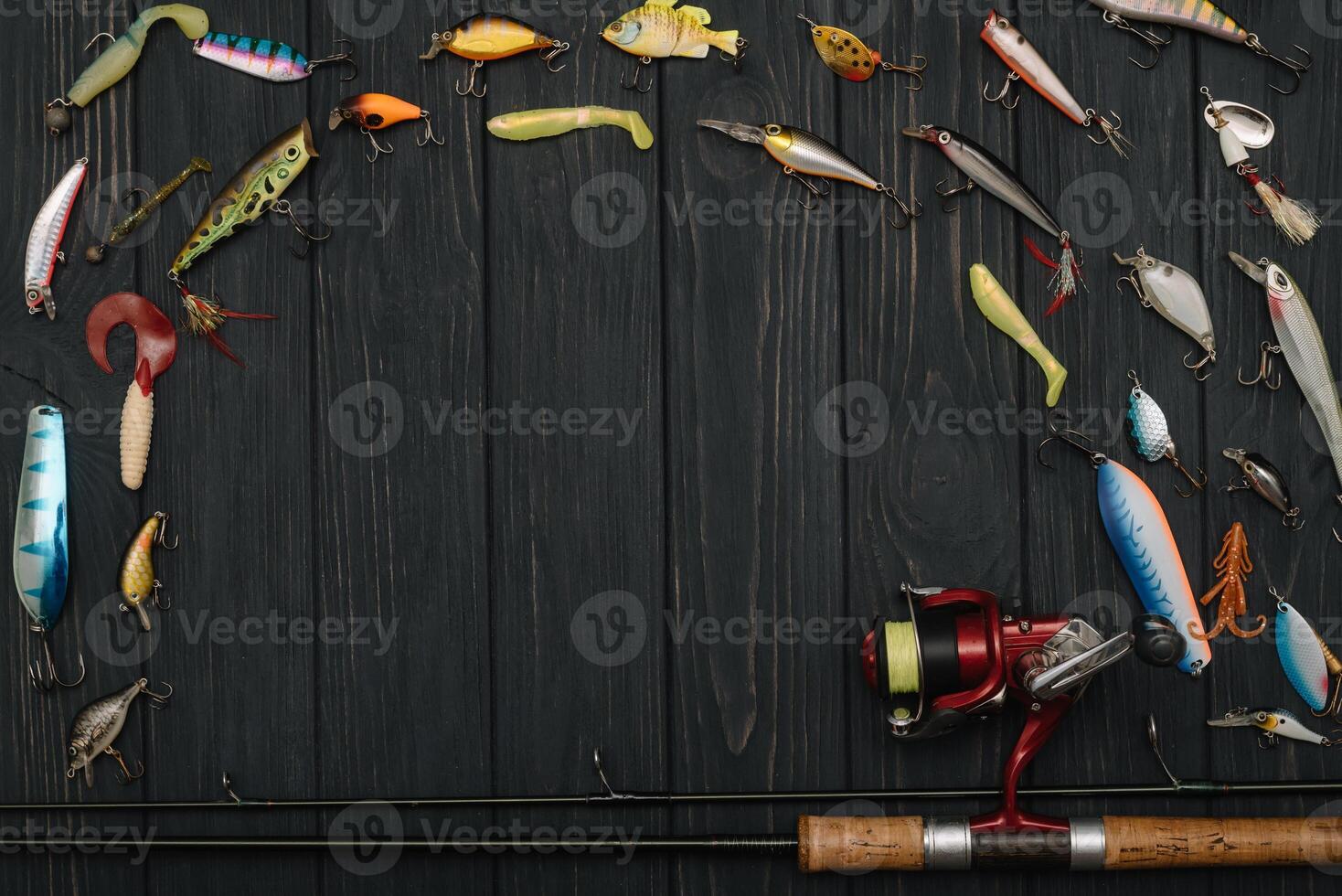 Fishing tackle - fishing spinning, hooks and lures on darken wooden background. Top view photo