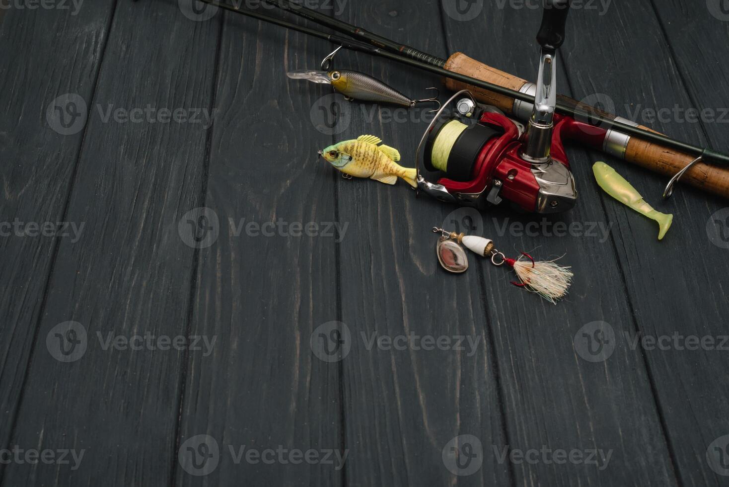 Fishing tackle - fishing spinning, hooks and lures on darken wooden background. Top view photo