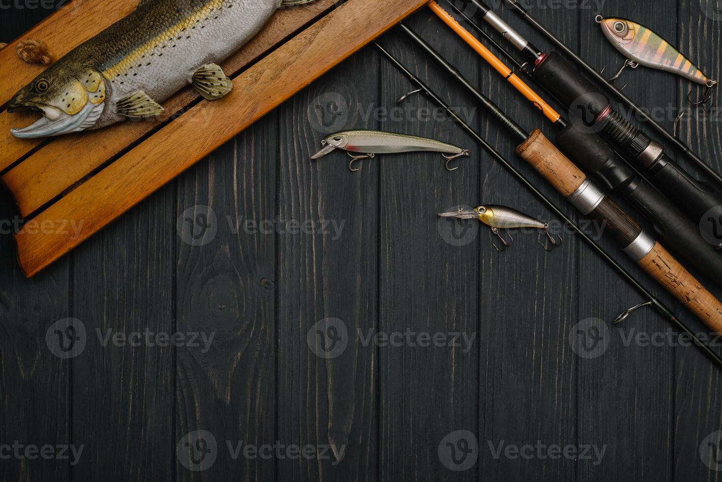 Fishing tackle - fishing spinning, hooks and lures on darken wooden background. Top view photo