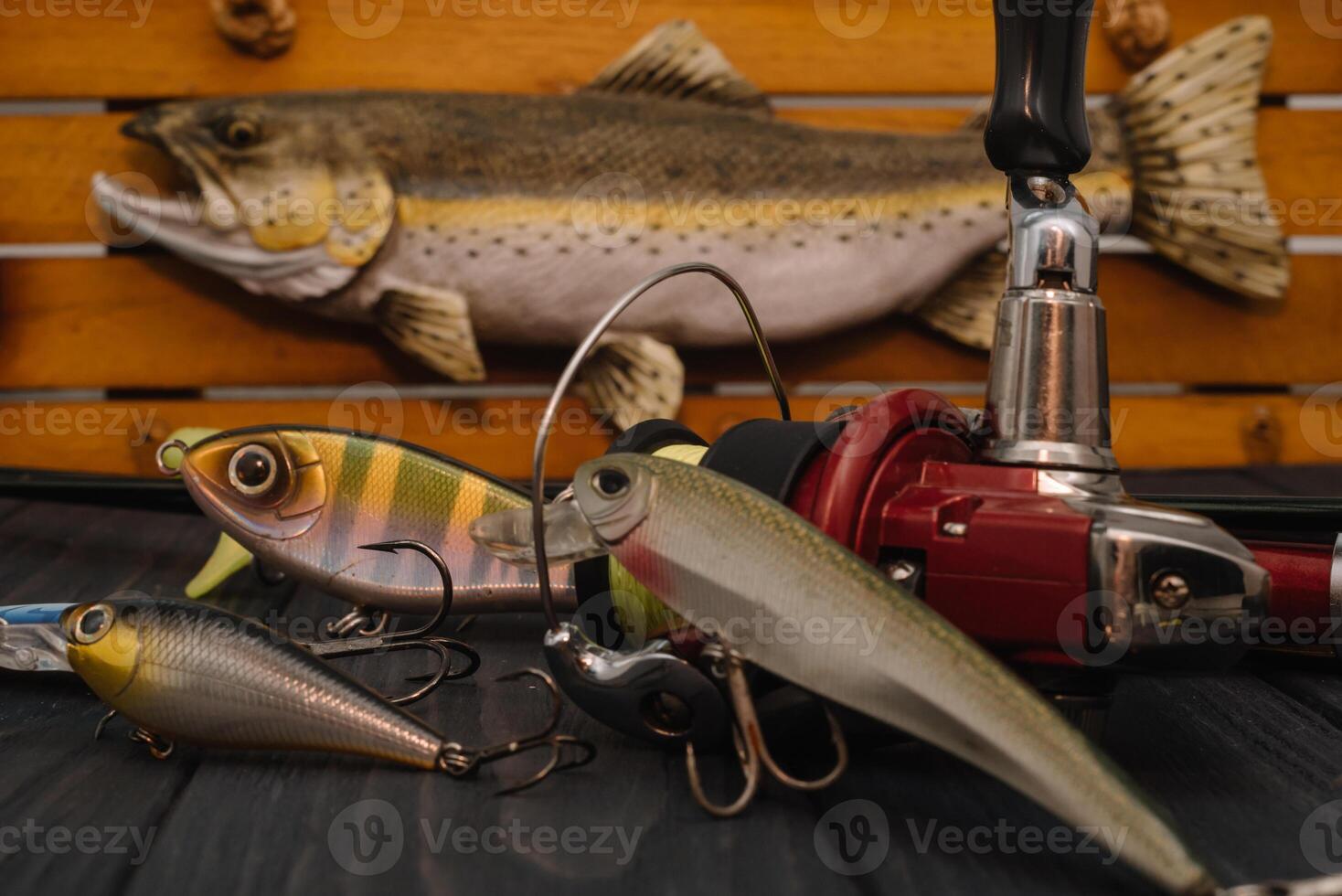 Fishing tackle - fishing spinning, hooks and lures on darken wooden background. Top view photo