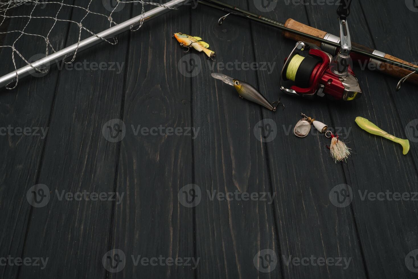 Fishing tackle - fishing spinning, hooks and lures on darken wooden background. Top view photo