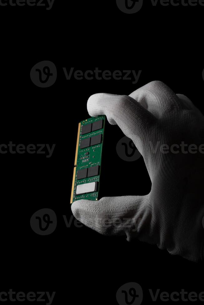 In the Darkness Hand Securely Grasping RAM DDR4 Sodimm for PC photo