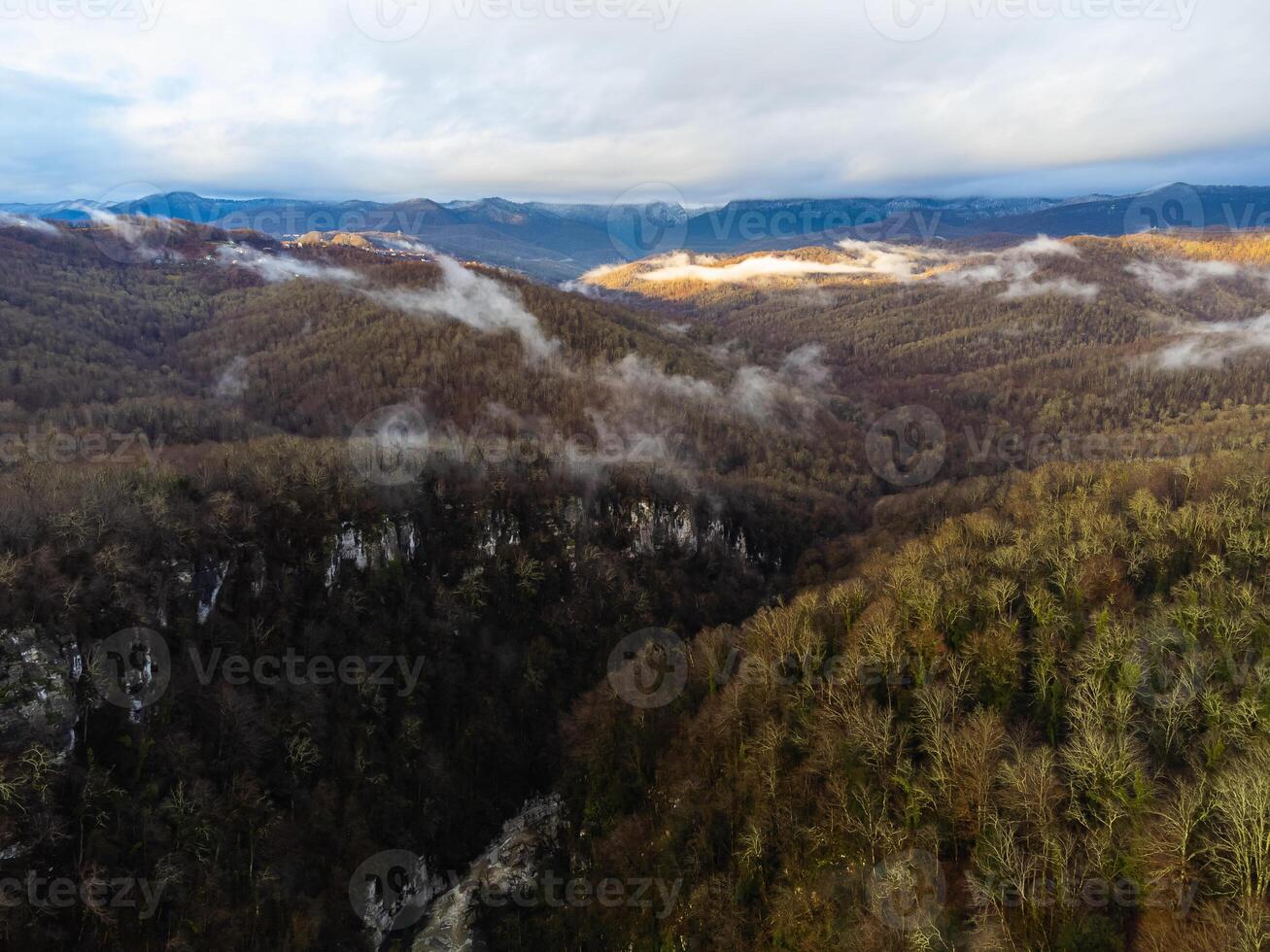 View of the autumn village in the mountains through the clouds photo