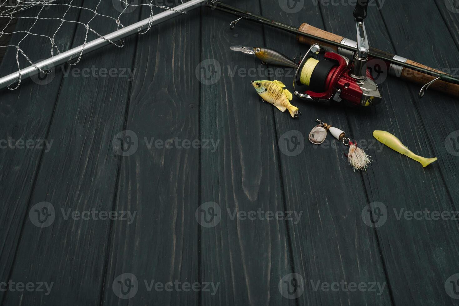 Fishing tackle - fishing spinning, hooks and lures on darken wooden background. Top view photo