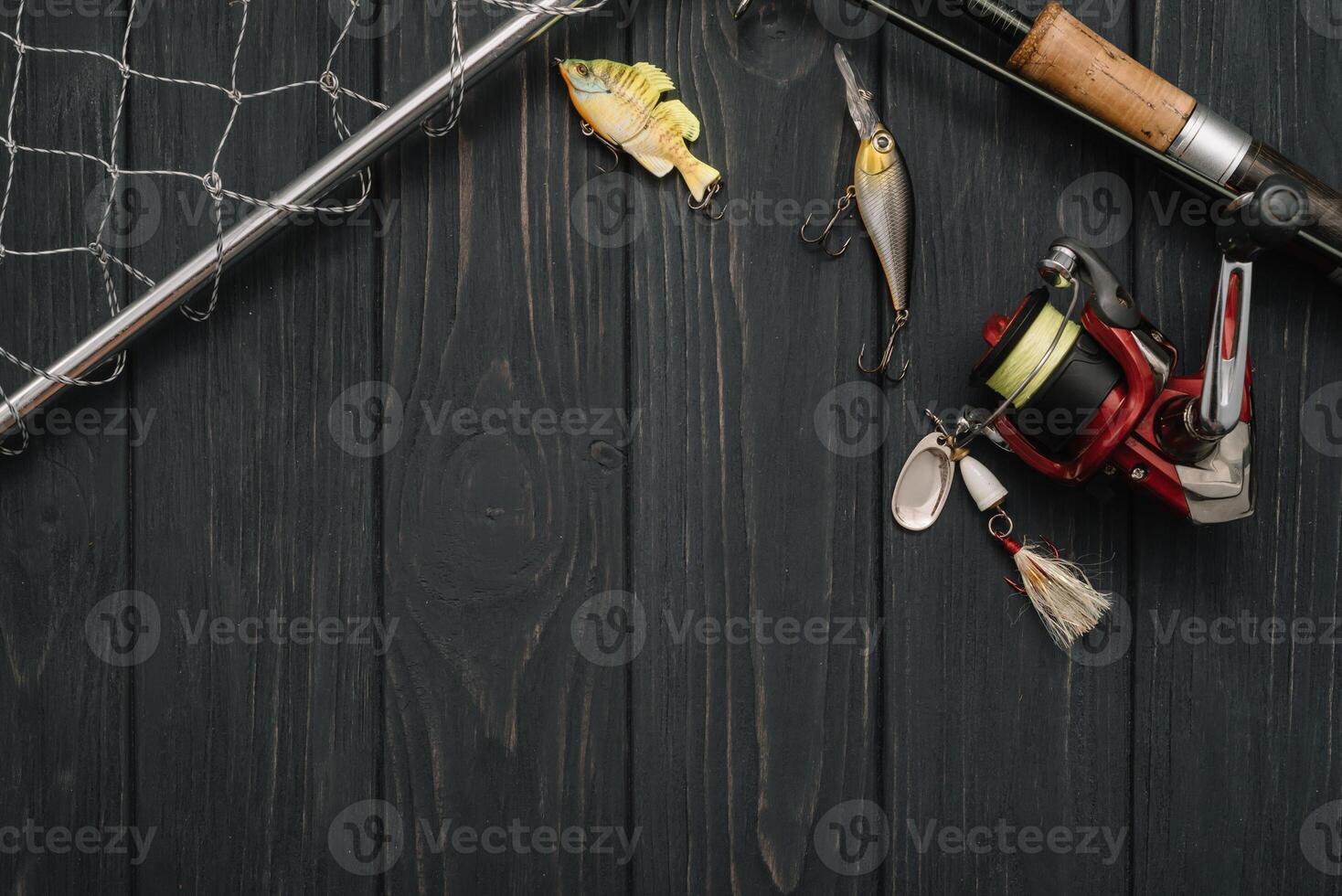 Fishing tackle - fishing spinning, hooks and lures on darken wooden background. Top view photo