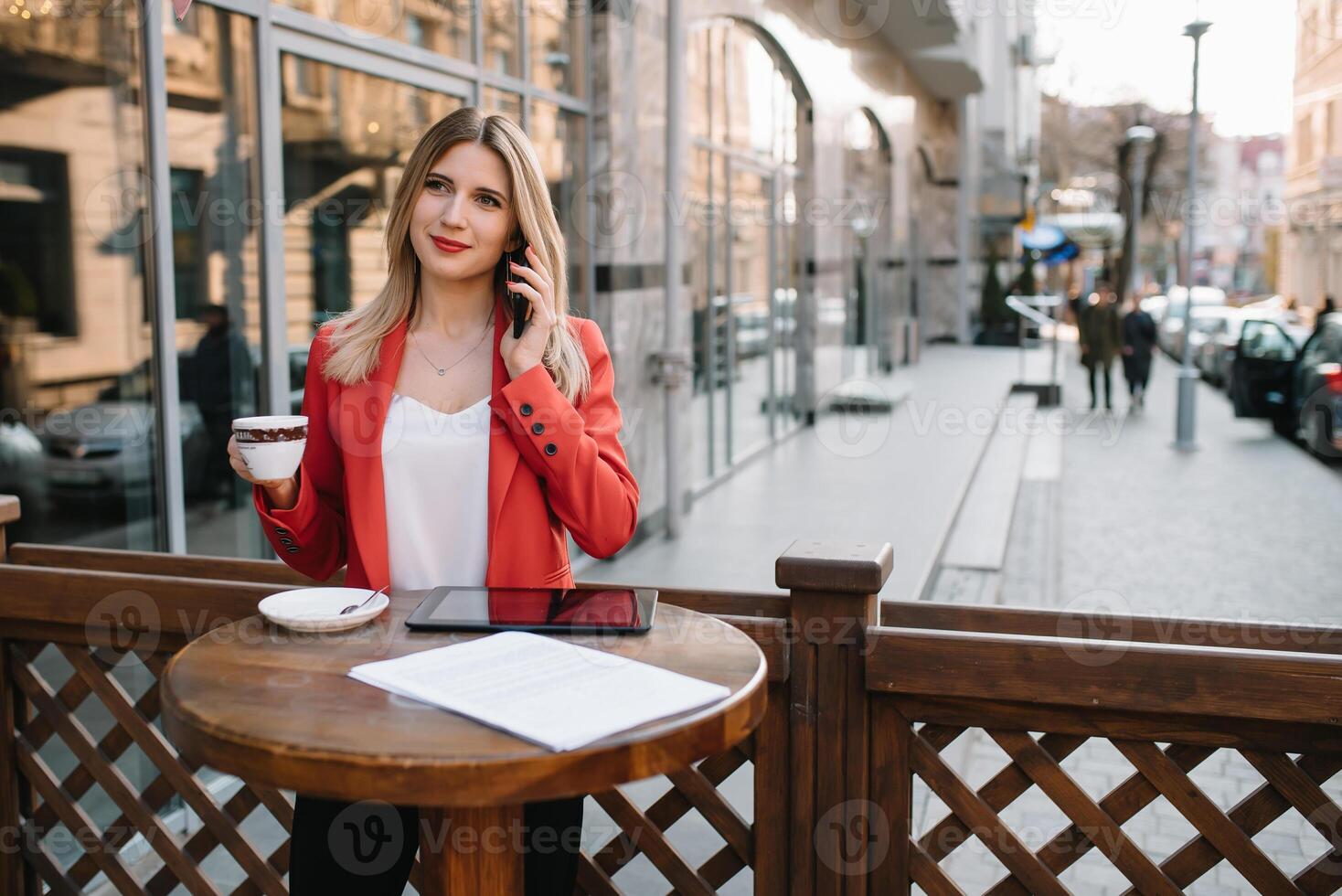 Businesswoman taking a coffee break and using smartphone photo