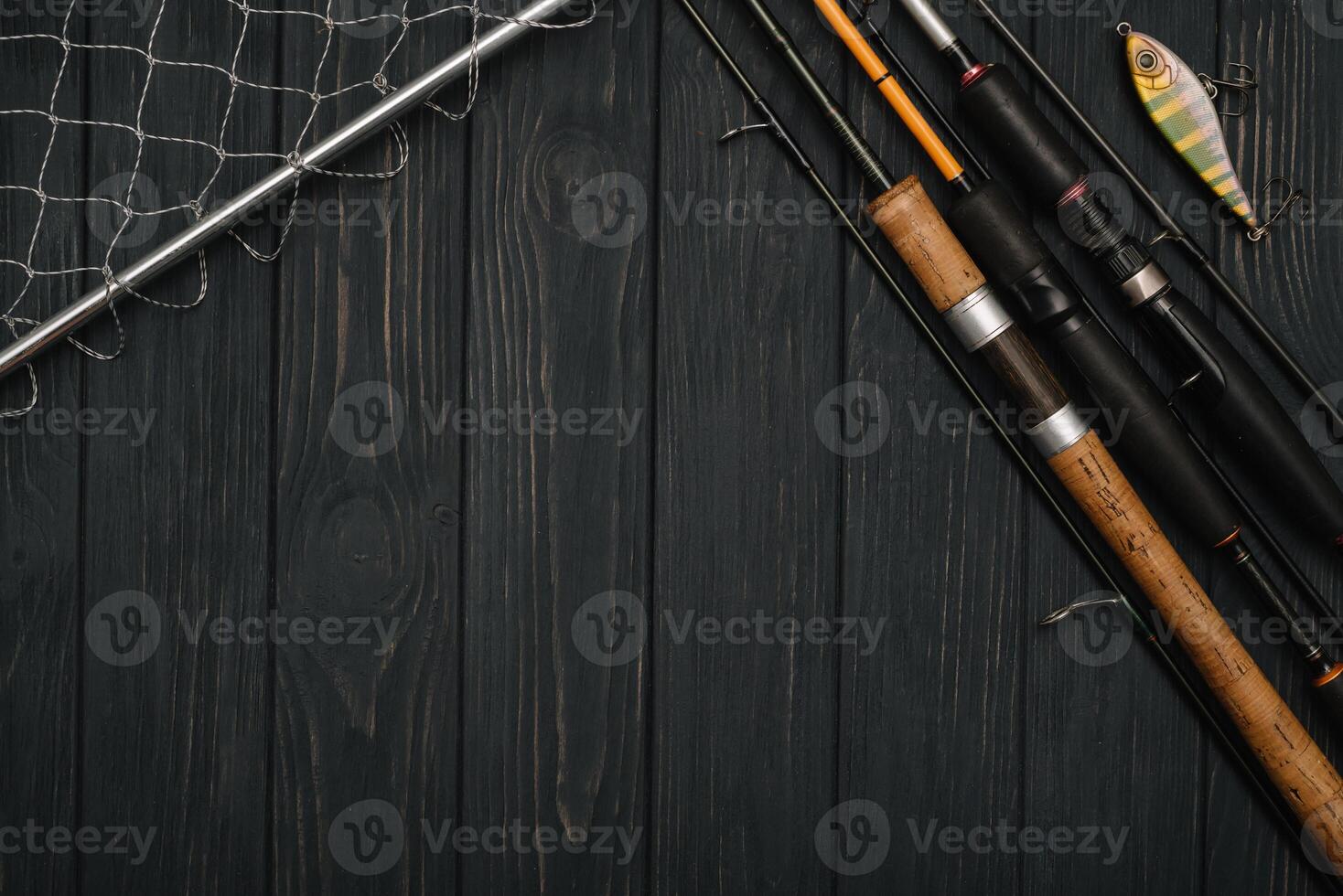 Fishing tackle - fishing spinning, hooks and lures on darken wooden background. Top view. photo