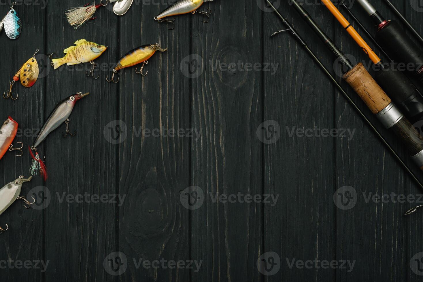 Fishing tackle - fishing spinning, hooks and lures on darken wooden background. Top view photo