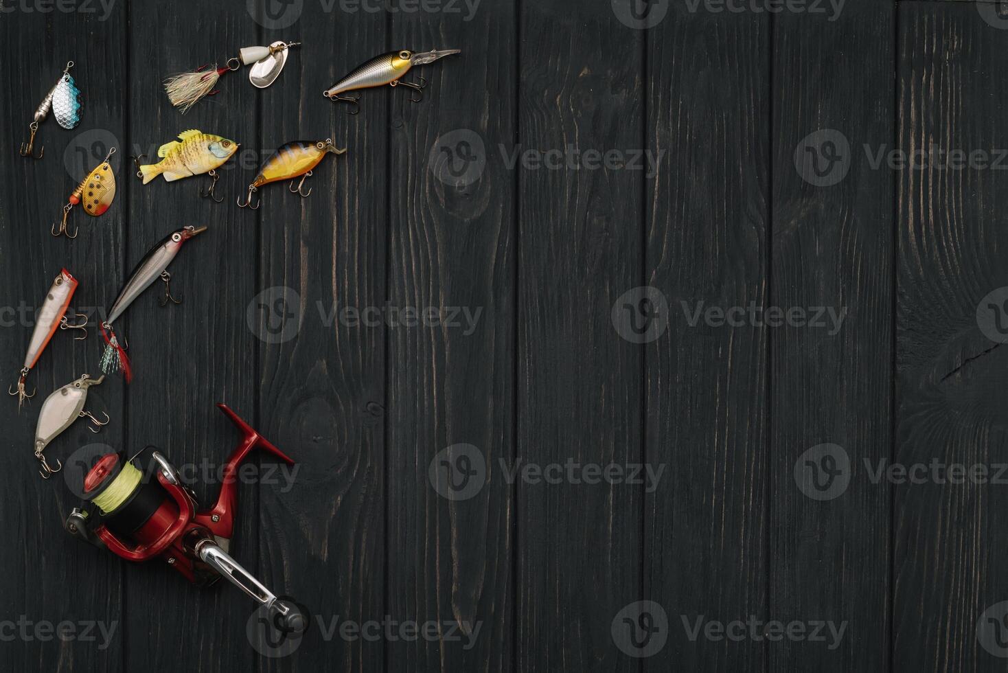 Fishing tackle - fishing spinning, hooks and lures on darken wooden background. Top view photo