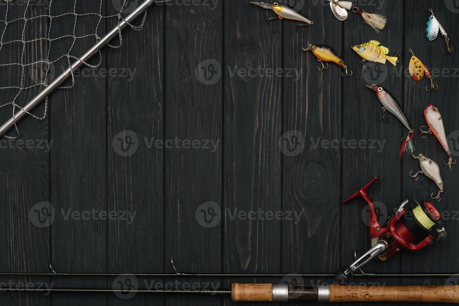 Fishing tackle - fishing spinning, hooks and lures on darken wooden background. Top view photo