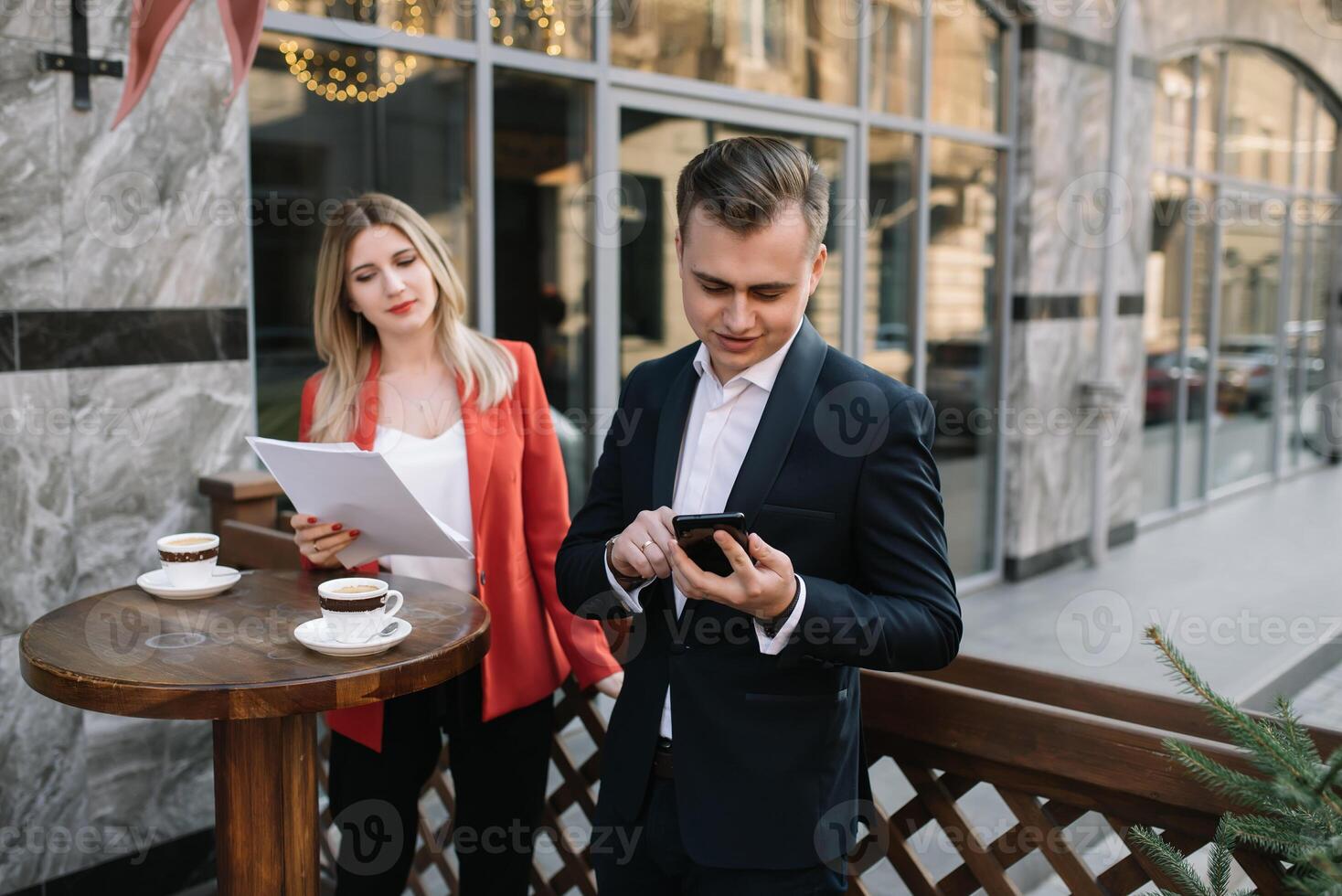 Handsome and Confident Businessman Using Laptop Computer and Technology Gadget Smartphone outdoor Discussing With Beautiful Business Partner .New Modern Business People Lifestyle photo