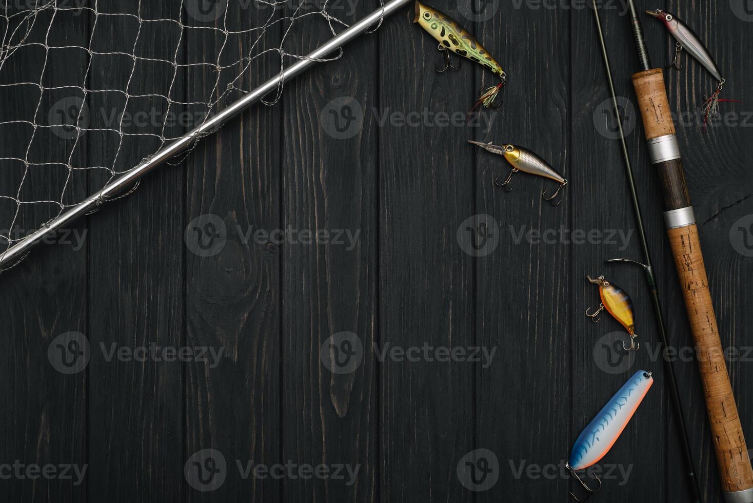 Fishing tackle - fishing spinning, hooks and lures on darken wooden background. Top view photo