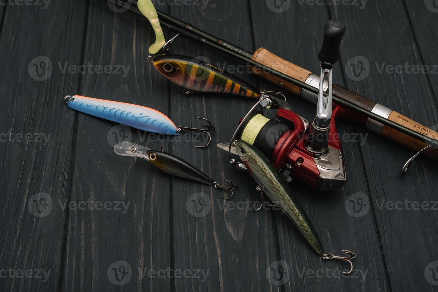 Fishing tackle - fishing spinning, hooks and lures on darken wooden background. Top view photo