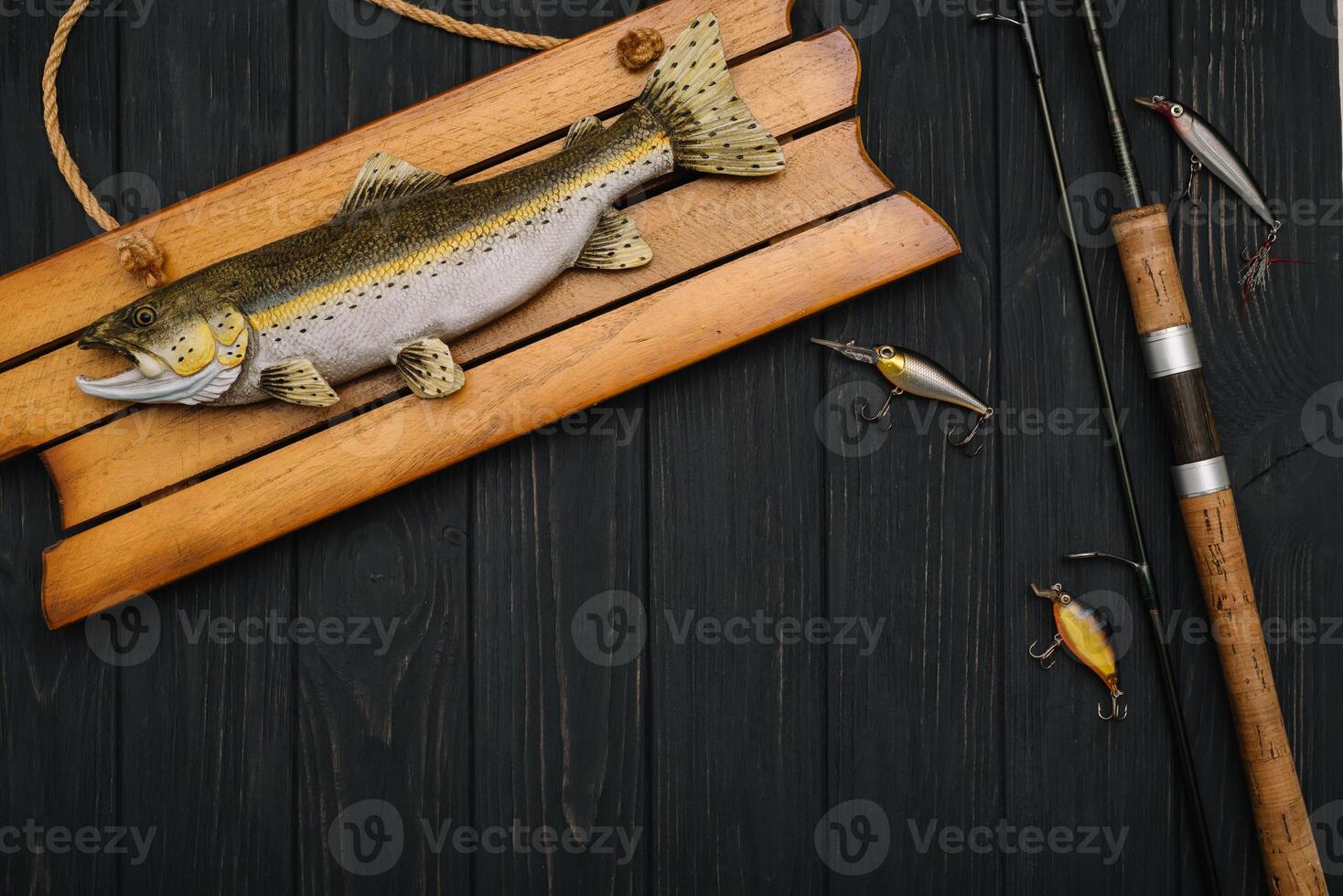 Fishing tackle - fishing spinning, hooks and lures on darken wooden background. Top view photo