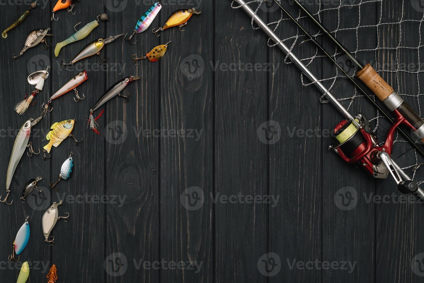 Fishing tackle - fishing spinning, hooks and lures on darken wooden background. Top view photo