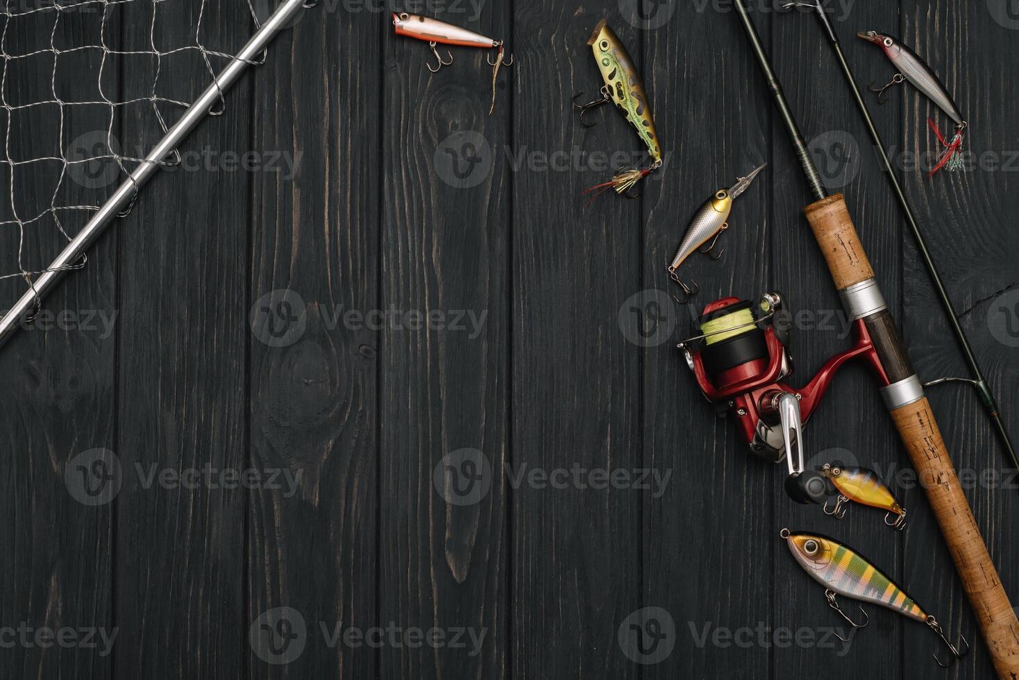 Fishing tackle - fishing spinning, hooks and lures on darken wooden background. Top view photo