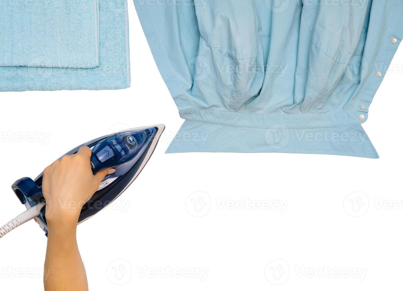 Female hand ironing clothes top view isolated on white background. Young woman with iron ironing man's shirt seen from above during housework. Blue iron on white table photo