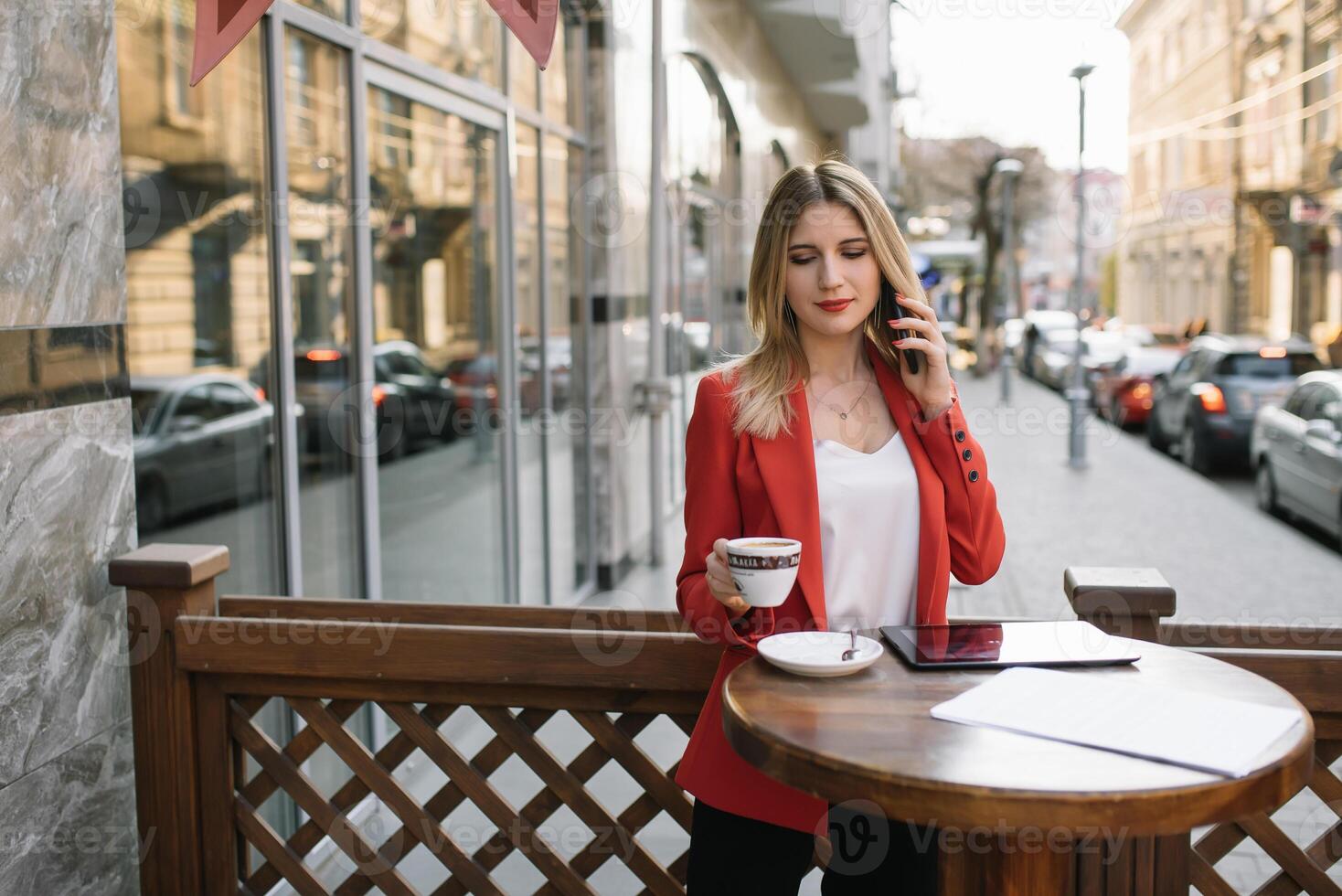 Businesswoman taking a coffee break and using smartphone photo