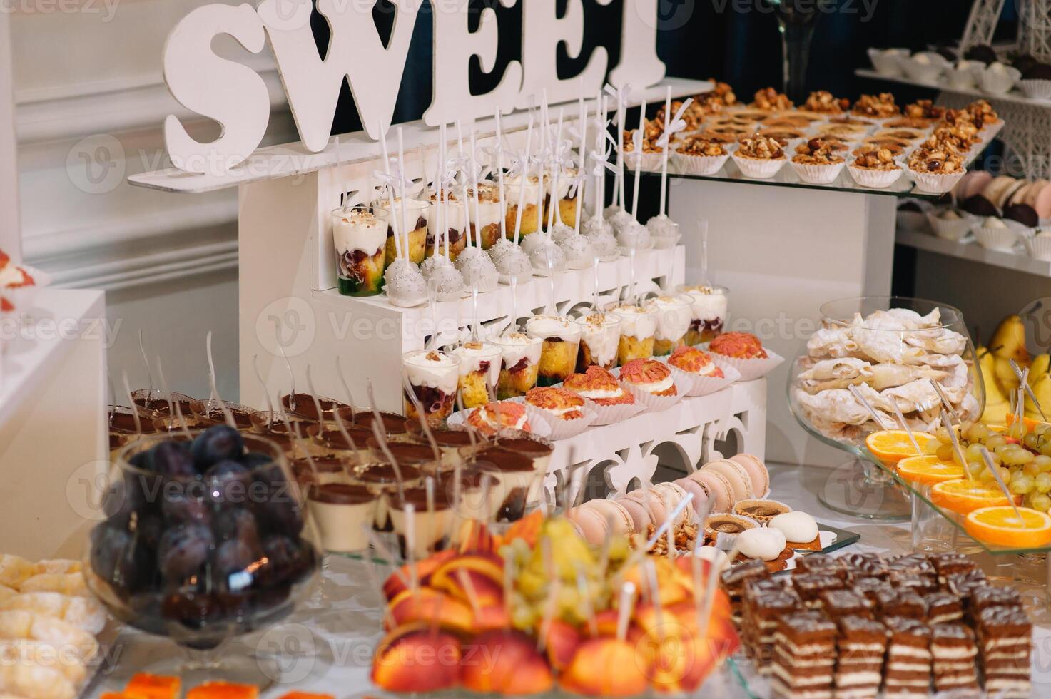 desserts with fruits, mousse, biscuits. Different types of sweet pastries, small colorful sweet cakes, macaron, and other desserts in the sweet buffet. candy bar for birthday. photo