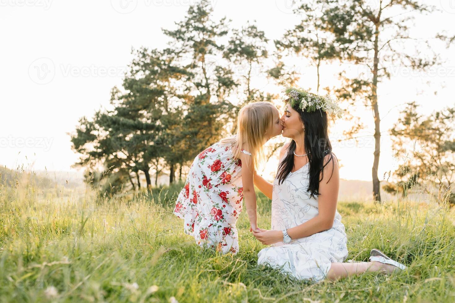 elegante madre y hermoso hija teniendo divertido en el naturaleza. contento familia concepto. belleza naturaleza escena con familia al aire libre estilo de vida. familia descansando juntos. felicidad en familia vida. madres día. foto