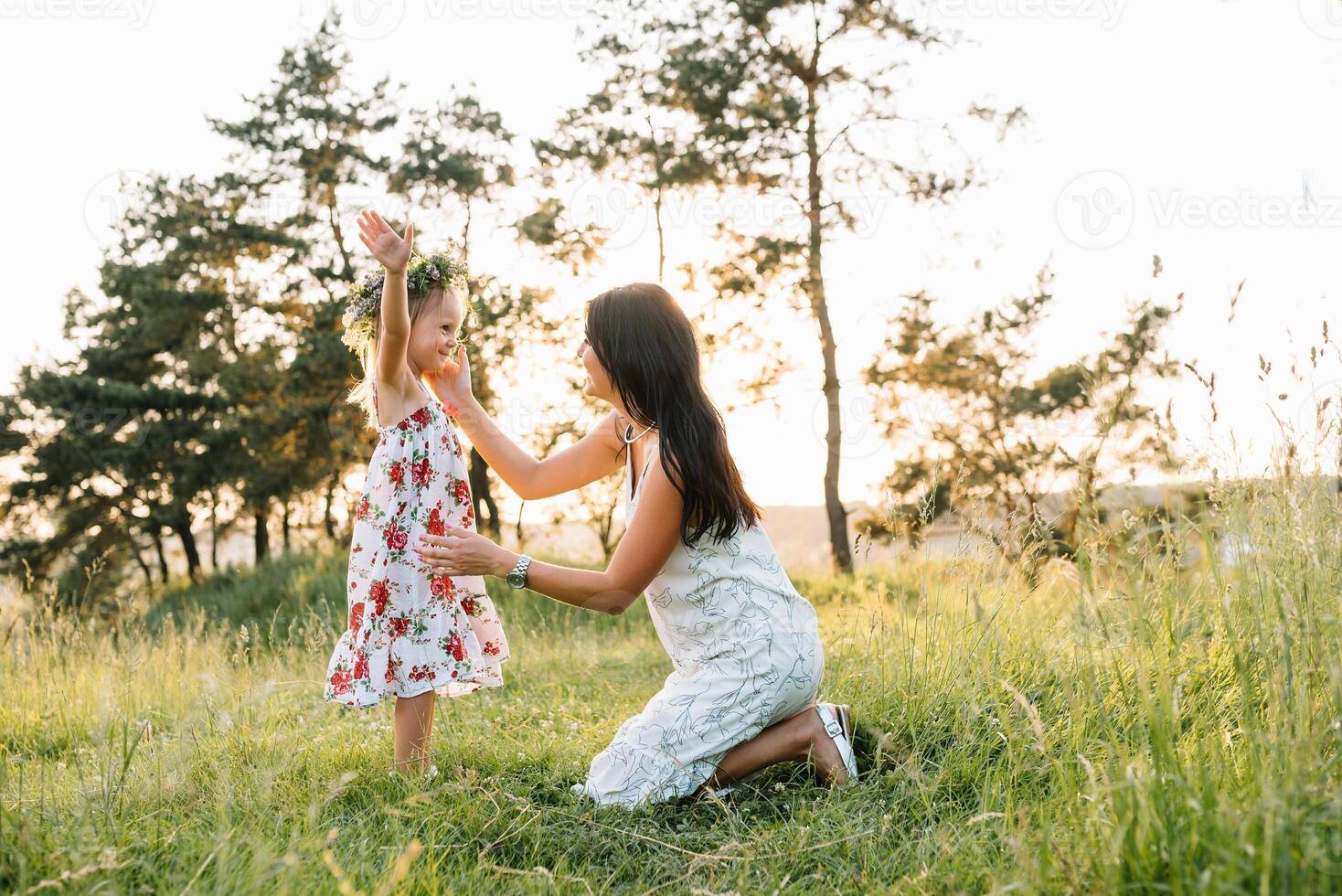 elegante madre y hermoso hija teniendo divertido en el naturaleza. contento familia concepto. belleza naturaleza escena con familia al aire libre estilo de vida. familia descansando juntos. felicidad en familia vida. madres día. foto