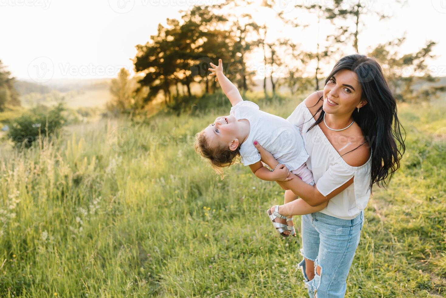 elegante madre y hermoso hija teniendo divertido en el naturaleza. contento familia concepto. belleza naturaleza escena con familia al aire libre estilo de vida. familia descansando juntos. felicidad en familia vida. madres día. foto