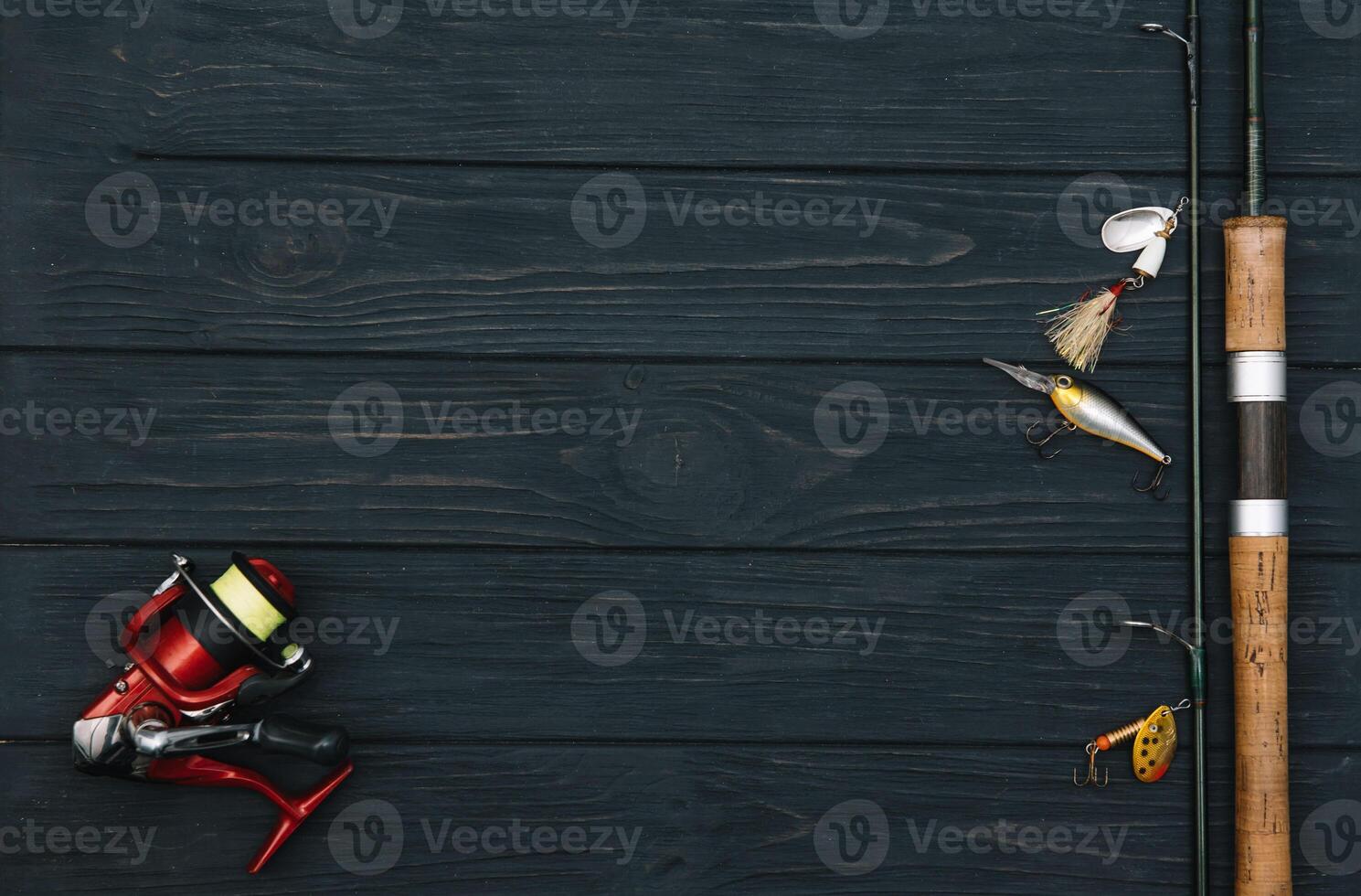 Fishing tackle - fishing spinning, hooks and lures on darken wooden background. Top view. photo