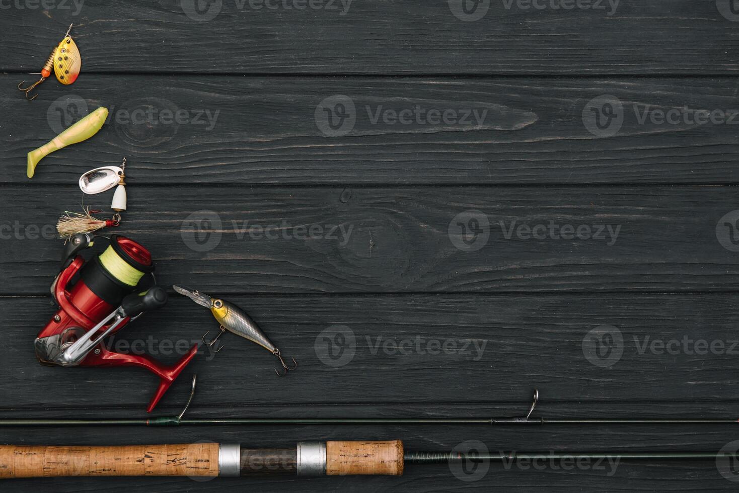 Fishing tackle - fishing spinning, hooks and lures on darken wooden background. Top view. photo