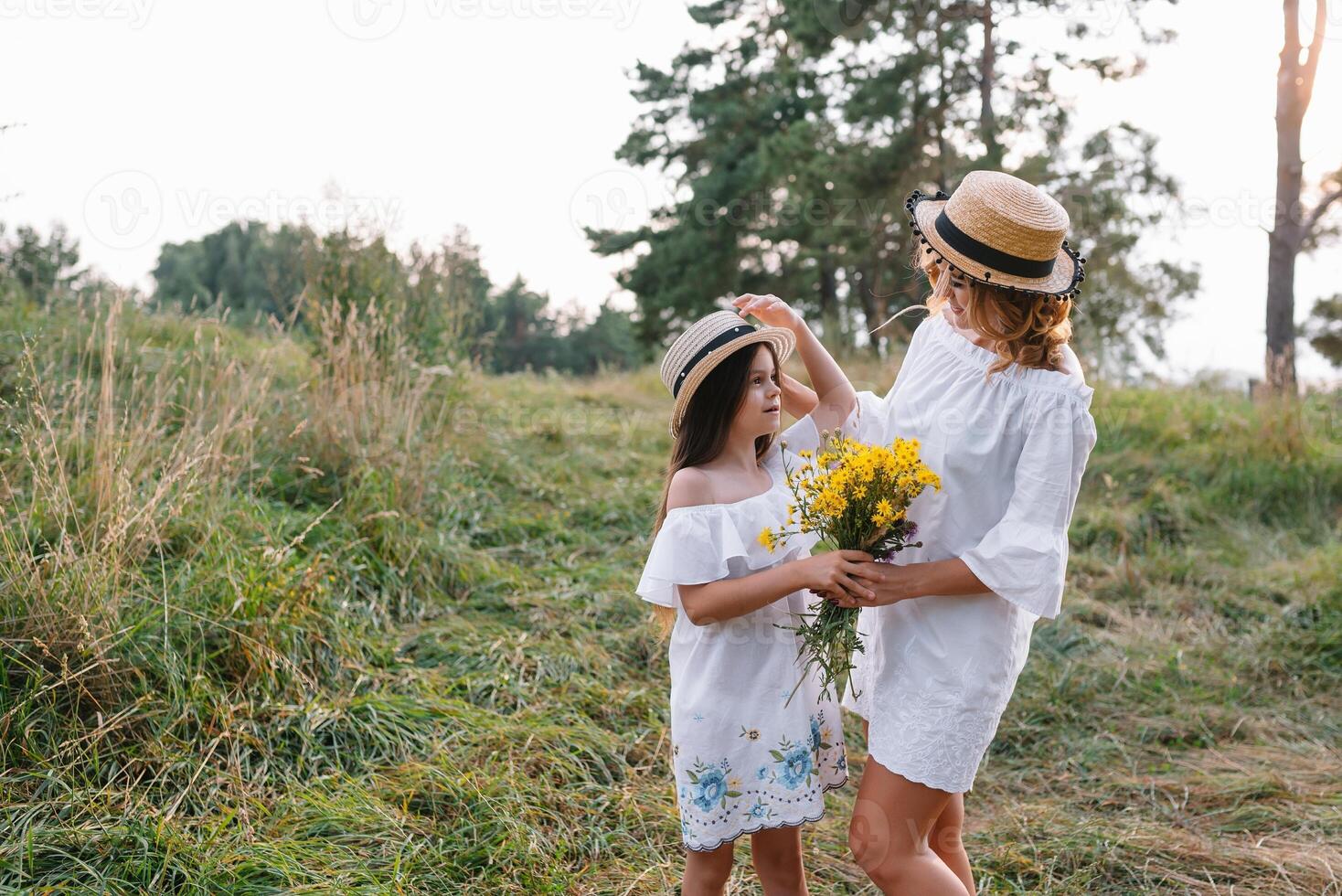 elegante madre y hermoso hija teniendo divertido en el naturaleza. contento familia concepto. belleza naturaleza escena con familia al aire libre estilo de vida. familia descansando juntos. felicidad en familia vida. madres día. foto