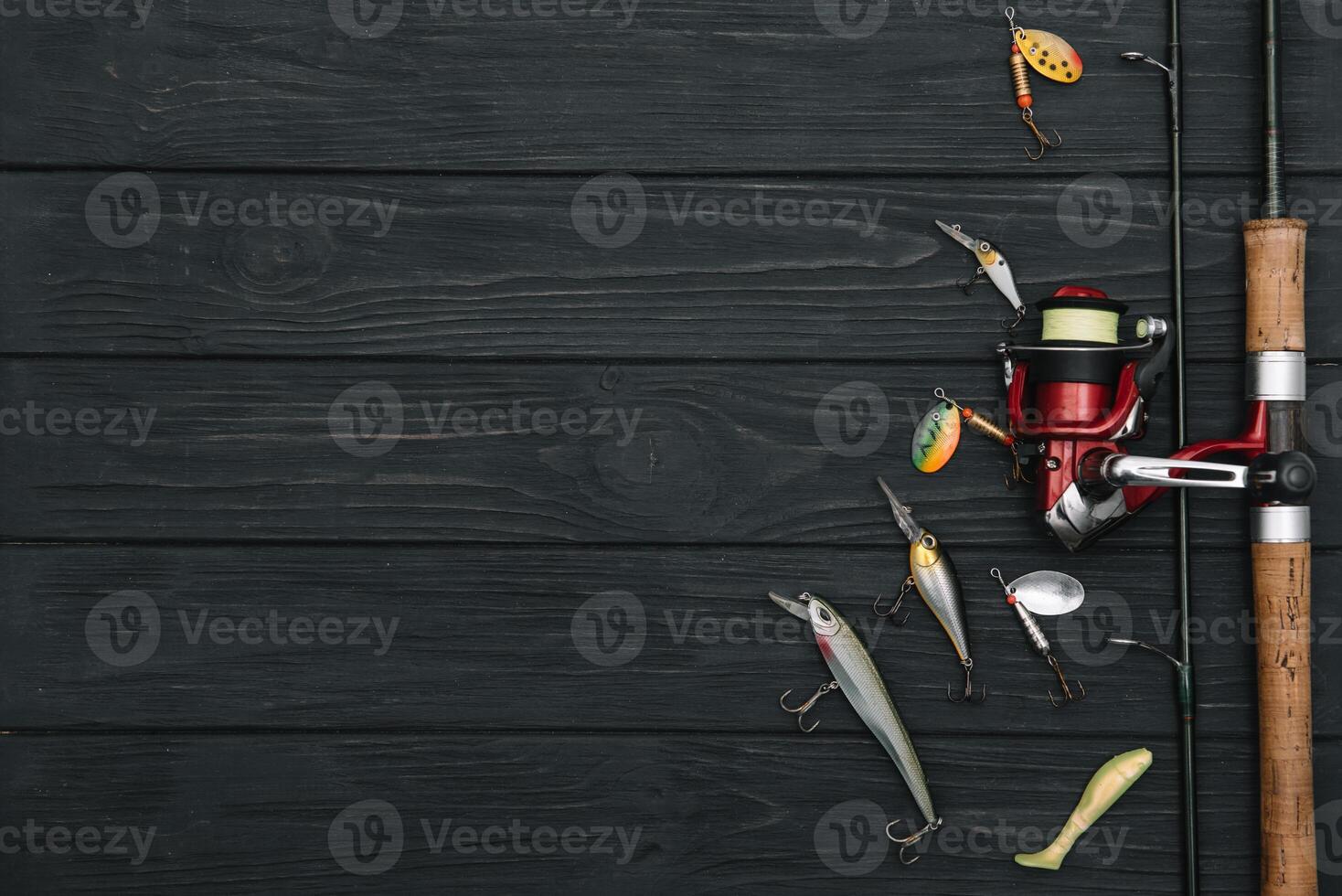 Fishing tackle - fishing spinning, hooks and lures on darken wooden background. Top view photo