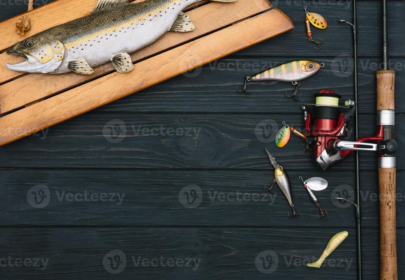 Fishing tackle - fishing spinning, hooks and lures on darken wooden background. Top view photo