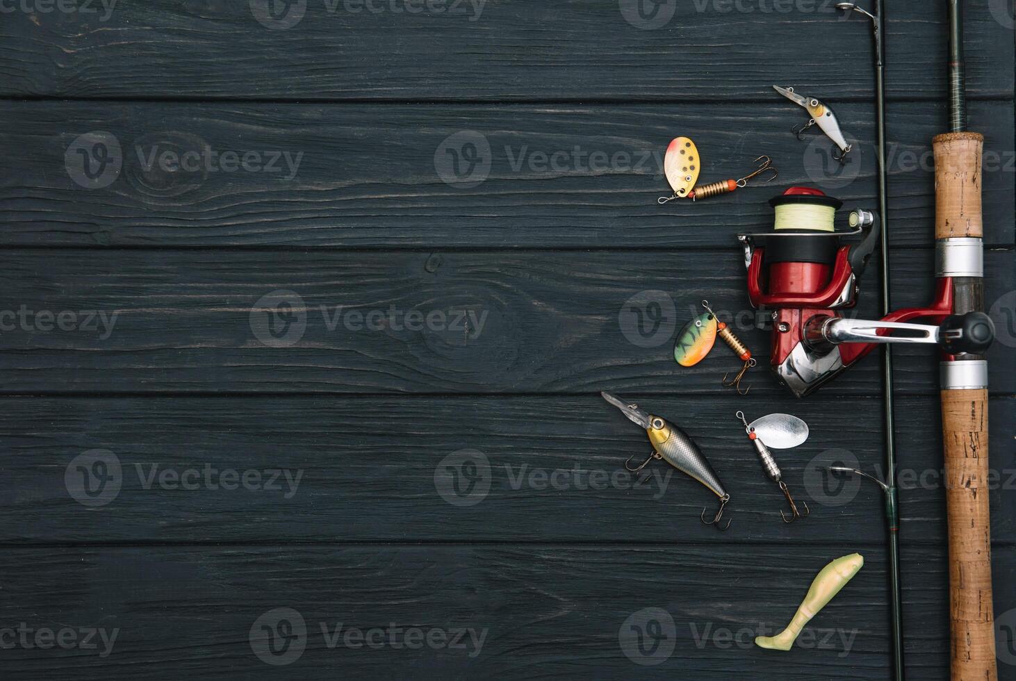 Fishing tackle - fishing spinning, hooks and lures on darken wooden background. Top view photo