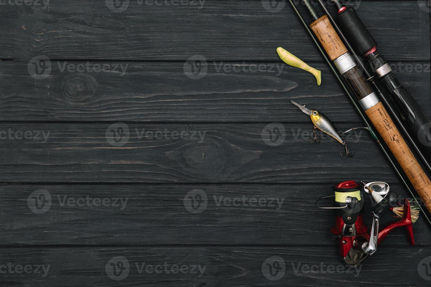 Fishing tackle - fishing spinning, hooks and lures on darken wooden background. Top view. photo