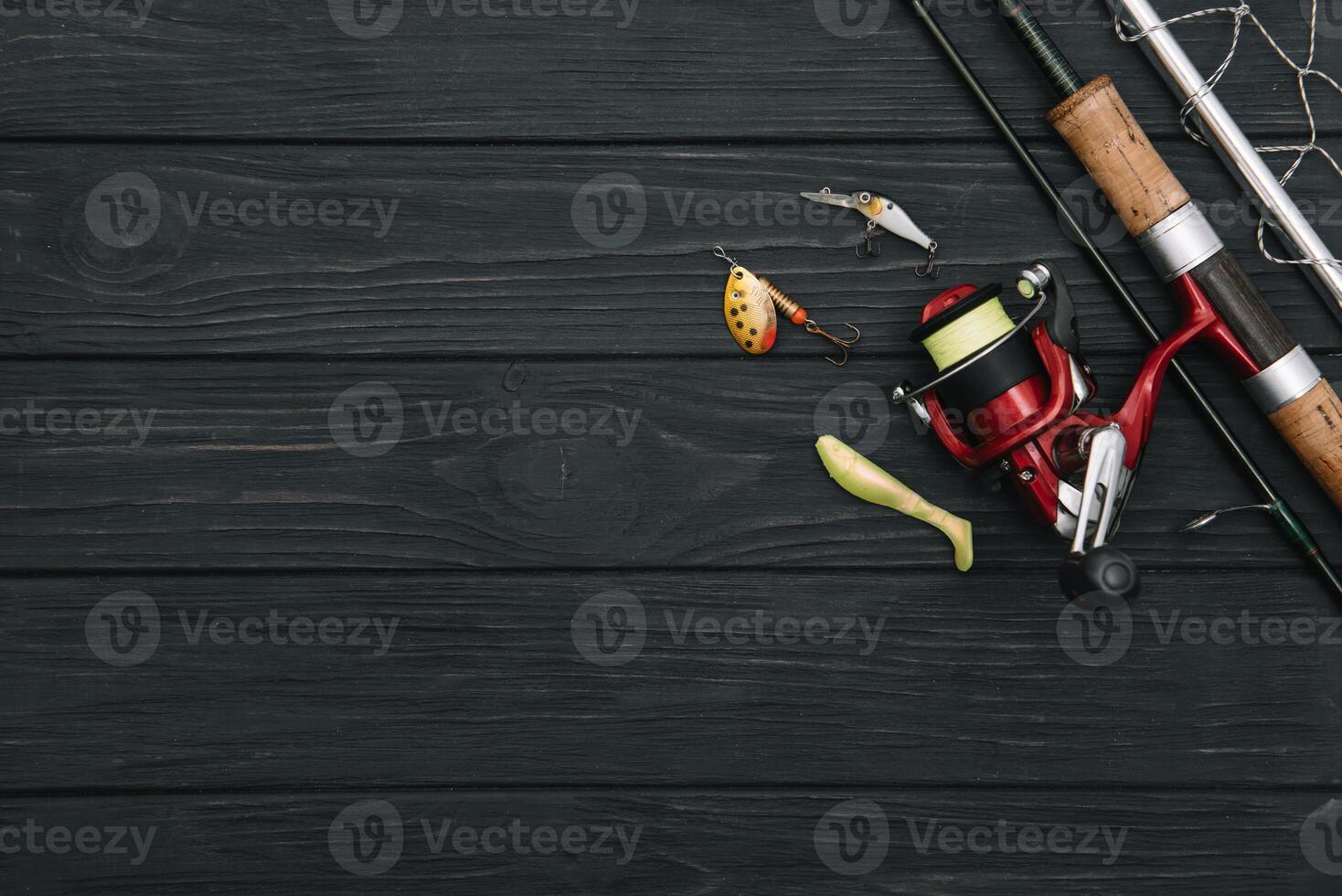 Fishing tackle - fishing spinning, hooks and lures on darken wooden background. Top view photo