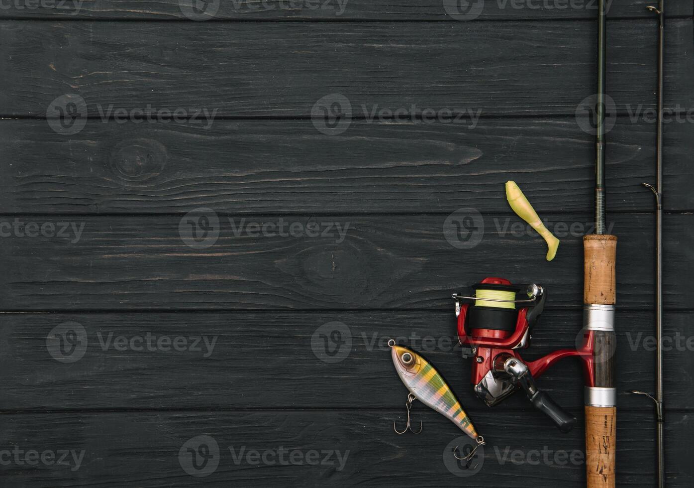 Fishing tackle - fishing spinning, hooks and lures on darken wooden background. Top view. photo