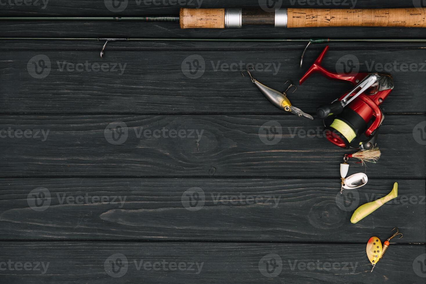 Fishing tackle - fishing spinning, hooks and lures on darken wooden background. Top view. photo