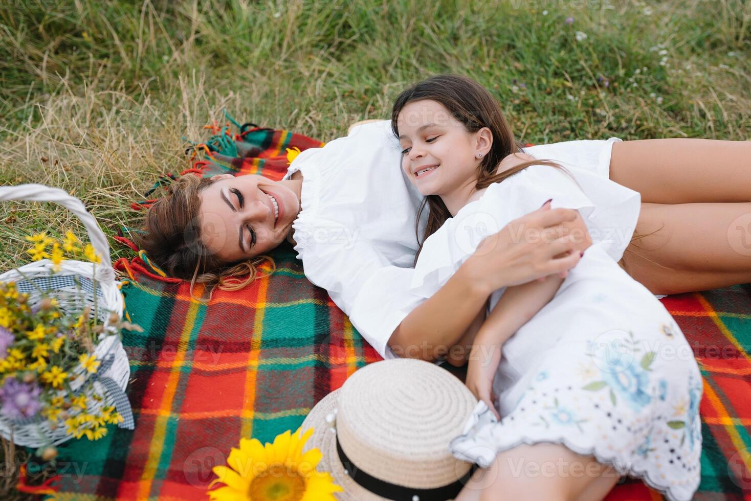 parte superior ver de contento mujer sonriente y jugando con su linda pequeño niño, acostado al aire libre.amoroso madre y hija gastar hora juntos en un parque. mamá y niño tiene divertida. de la madre día. foto