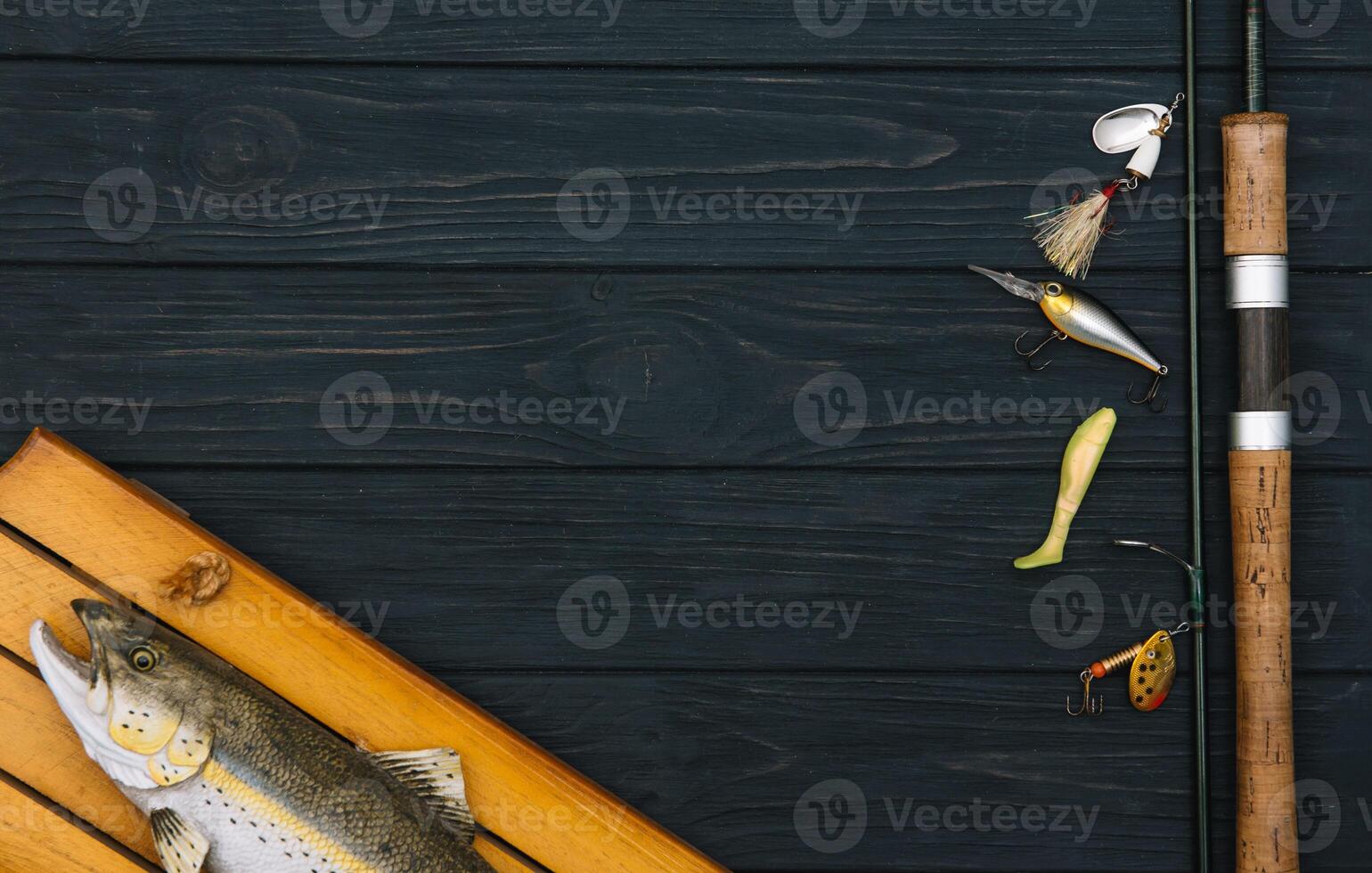 Fishing tackle - fishing spinning, hooks and lures on darken wooden background. Top view. photo