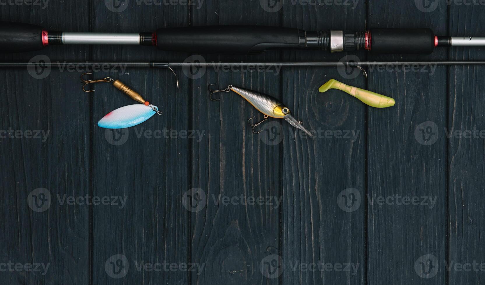 Fishing tackle - fishing spinning, hooks and lures on darken wooden background. Top view. photo