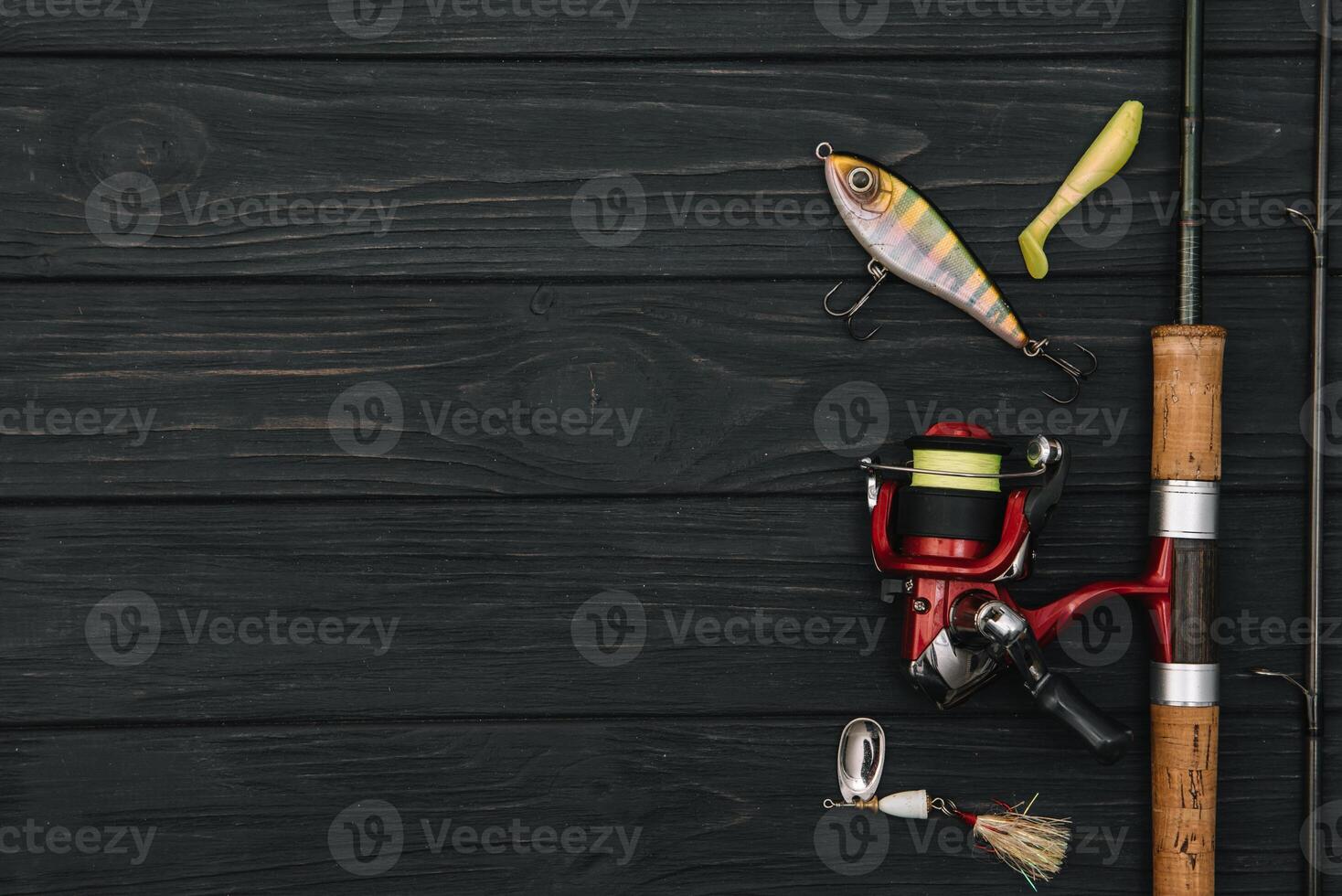 Fishing tackle - fishing spinning, hooks and lures on darken wooden background. Top view. photo