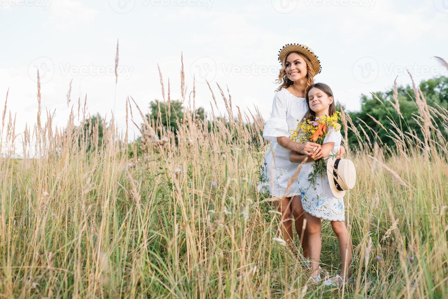 elegante madre y hermoso hija teniendo divertido en el naturaleza. contento familia concepto. belleza naturaleza escena con familia al aire libre estilo de vida. familia descansando juntos. felicidad en familia vida. madres día. foto