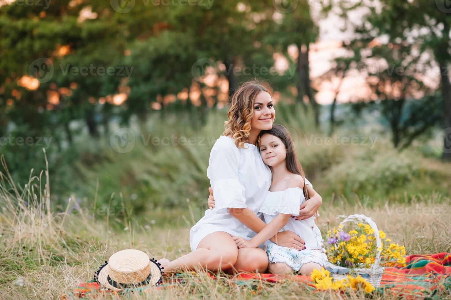 elegante madre y hermoso hija teniendo divertido en el naturaleza. contento familia concepto. belleza naturaleza escena con familia al aire libre estilo de vida. familia descansando juntos. felicidad en familia vida. madres día. foto