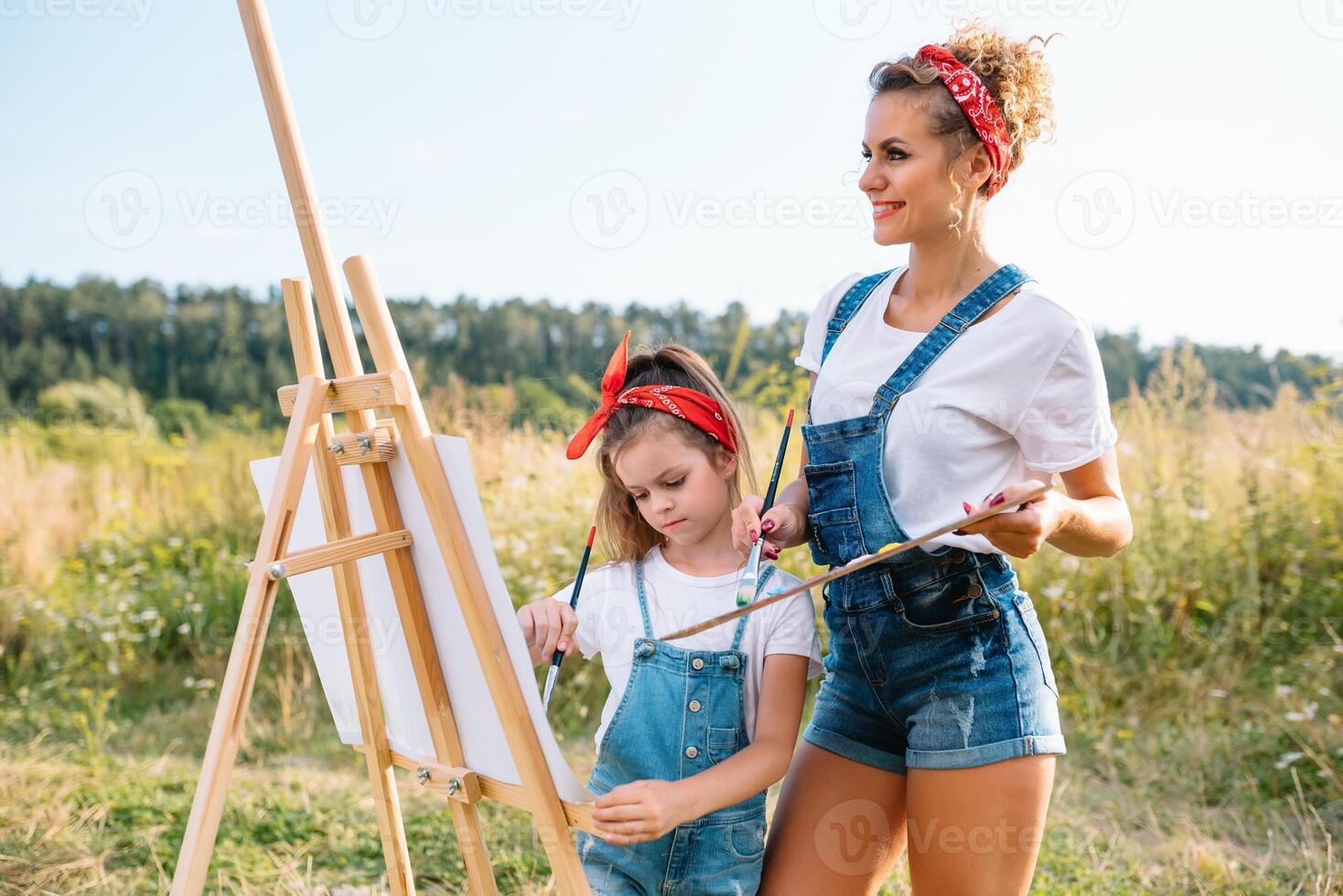 family, children and people concept - happy mother and daughter drawing and talking over green background. Mother's Day. photo